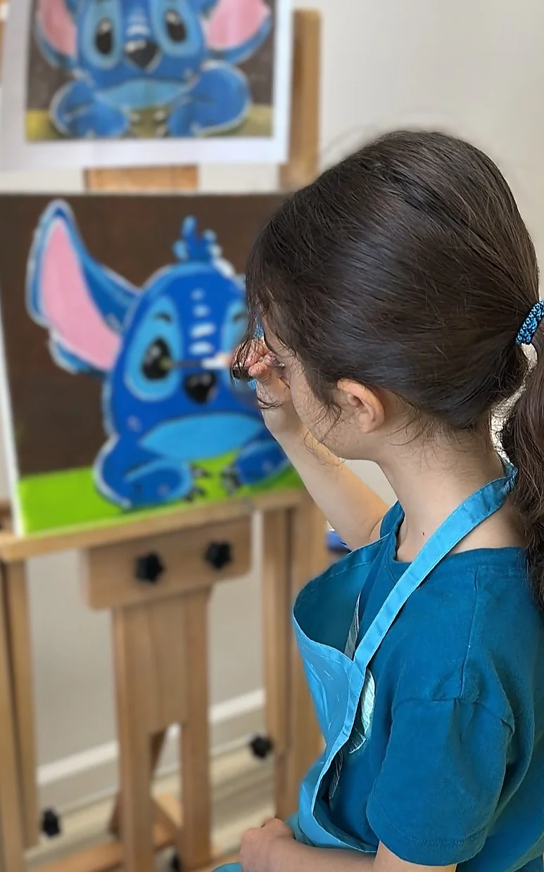 Student focused on painting details